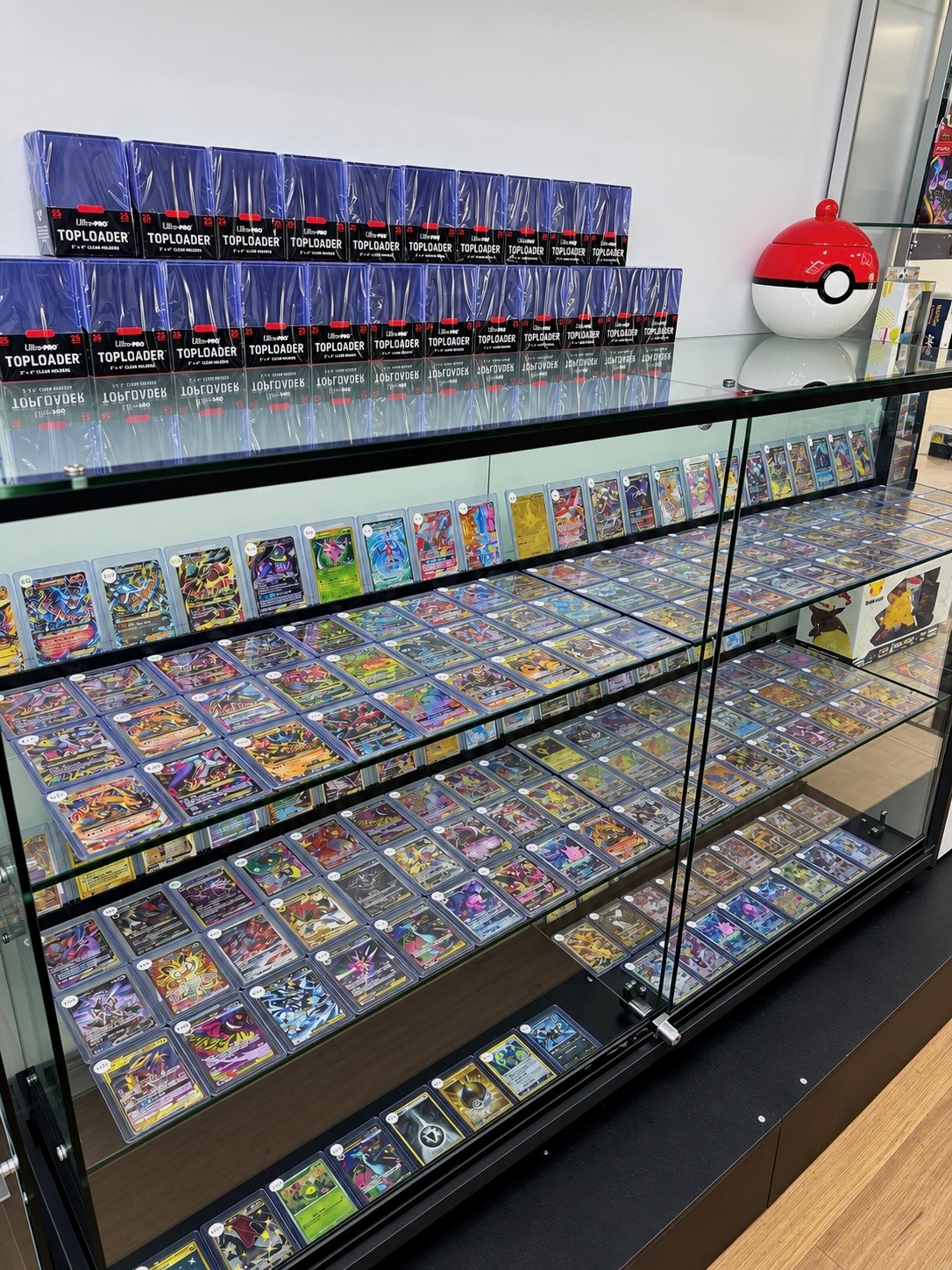 Trading card display cabinets and boxed products in the shop.