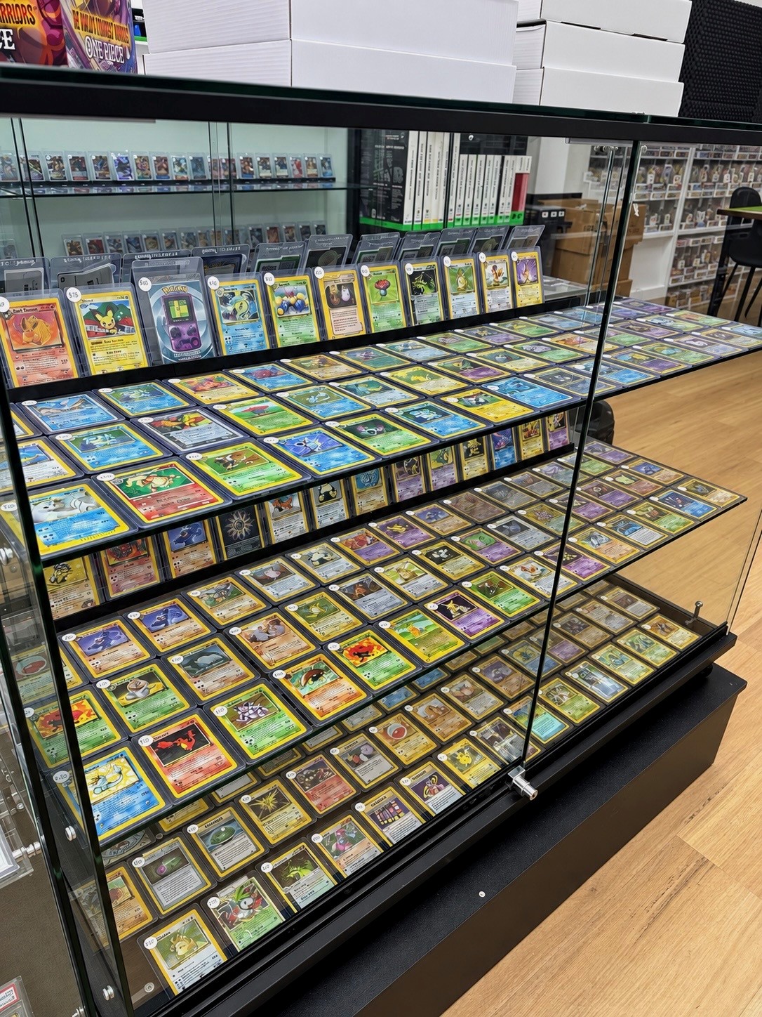 Trading cards displayed in rows in a glass cabinet.